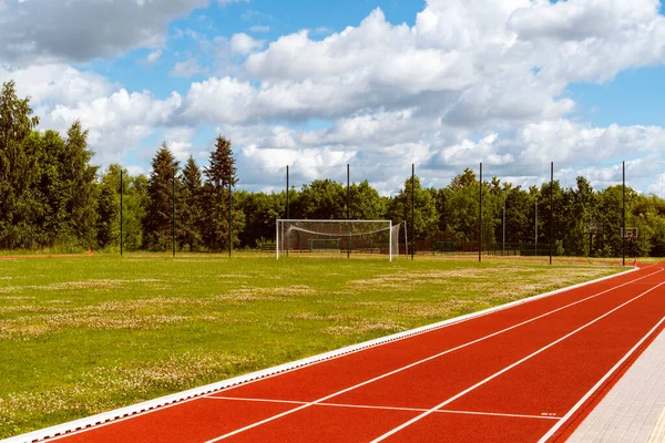 Empty school stadium with football gate and running track. Concept of training in football sections and schools, preparation for competitions and matches.