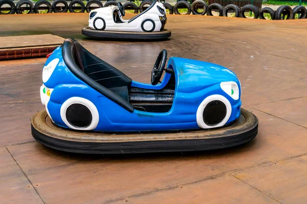 Electric bumper cars or dodgem cars at the amusement park. Fairground with attractions. Colorful dodgems.