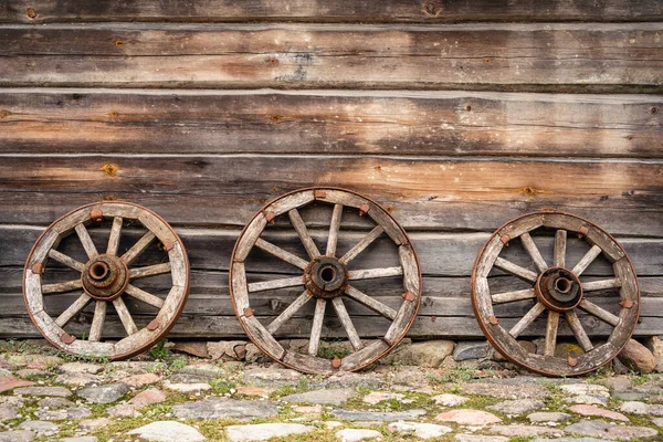 Three Old Wooden Wagon Wheels Leaning Log Cabin — стоковое фото