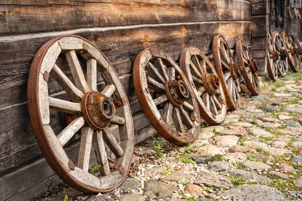Row Old Wooden Wagon Wheels Leaning Log Cabin — стоковое фото