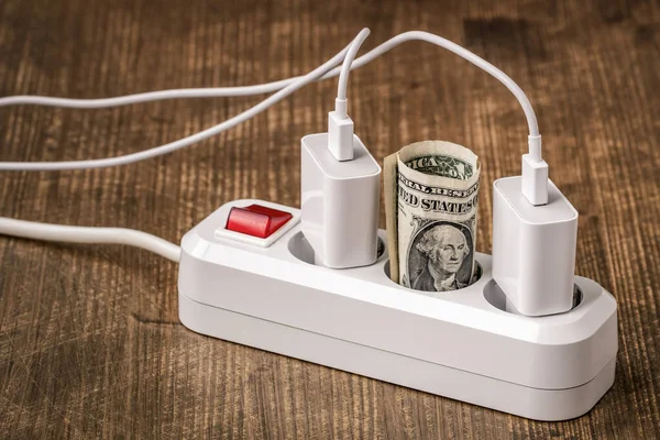Electric extension cord and money. Concept of energy savings. Energy crisis and power consumption.
