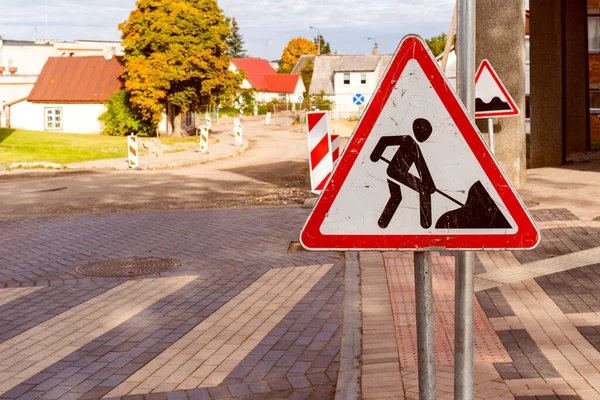 Road works sign for construction works in city street. Road under construction traffic sign.