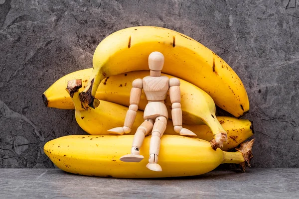 Wooden Mannequin Sitting Pile Yellow Bananas Dieting Concept — Stock Photo, Image