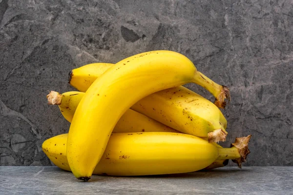 Banda Żółtych Bananów Szarym Kamiennym Tle — Zdjęcie stockowe