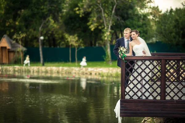 Bride and groom on the banks — Stock Photo, Image