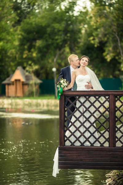 Bride and groom on the banks — Stock Photo, Image