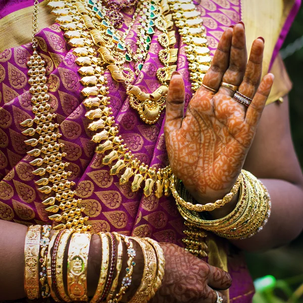 Handen van een Indiase bruid versierd met sieraden, armbanden en geschilderd met henna — Stockfoto