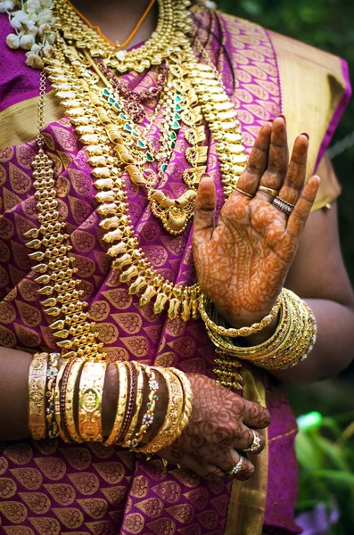 Hands of an Indian bride adorned with jewelery, bangles and painted with henna — Stock Photo, Image