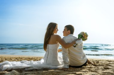 Gelin ve damat okyanusta kucaklayan