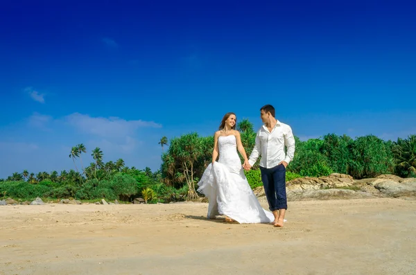 Sposi felici su una spiaggia selvaggia — Foto Stock