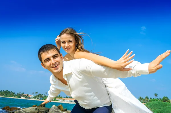 Šťastní novomanželé na divoké pláži — Stock fotografie