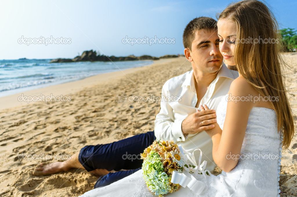 Bride and groom embracing on the ocean