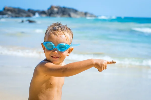 Chłopiec pływania okulary pokazuje palcem wskazującym — Zdjęcie stockowe