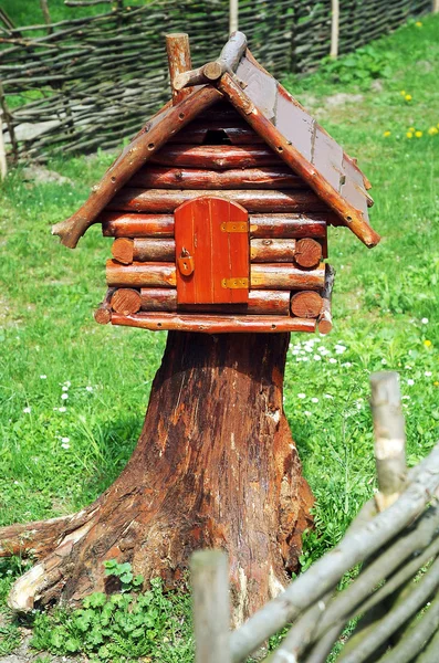 Holzhütte auf einem Holzstumpf Stockbild