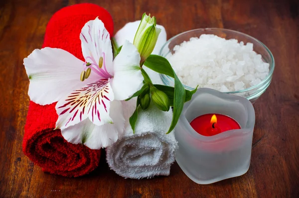 Red and white towels, aromatic salt and flower — Stock Photo, Image