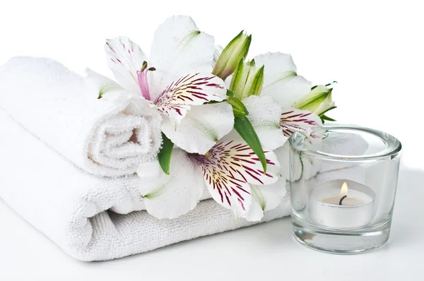 Resurser för spa, vit handduk, ljus och blomma — Stockfoto