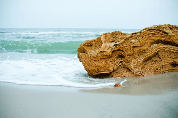 Желтый камень на пляже — стоковое фото