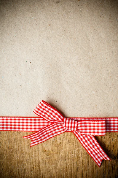 Wooden background, ribbon and kraft paper — Stock Photo, Image