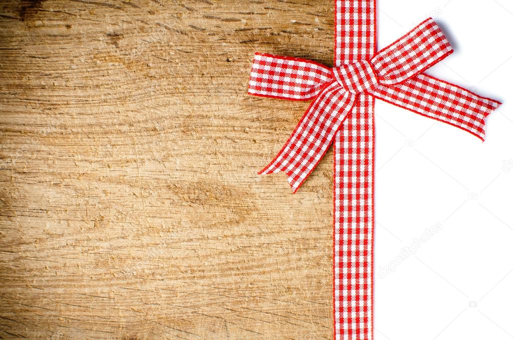 Wooden background with a red checkered ribbon