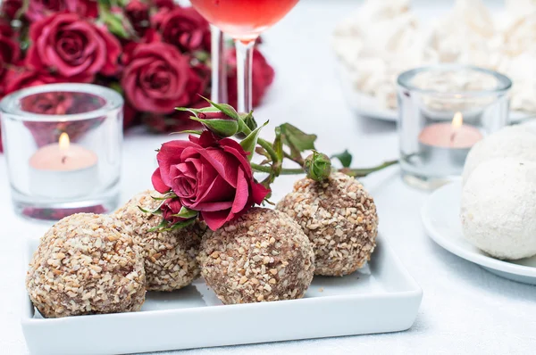 Pasteles de nuez y chocolate, flores y vino de rosas —  Fotos de Stock