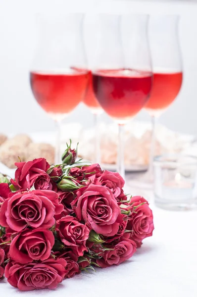 Rose e diversi bicchieri di vino rosato — Foto Stock