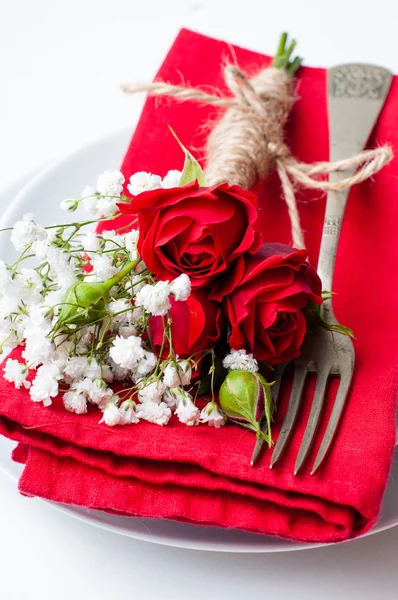 Mesa con rosas rojas, servilletas y vajilla vintage — Foto de Stock