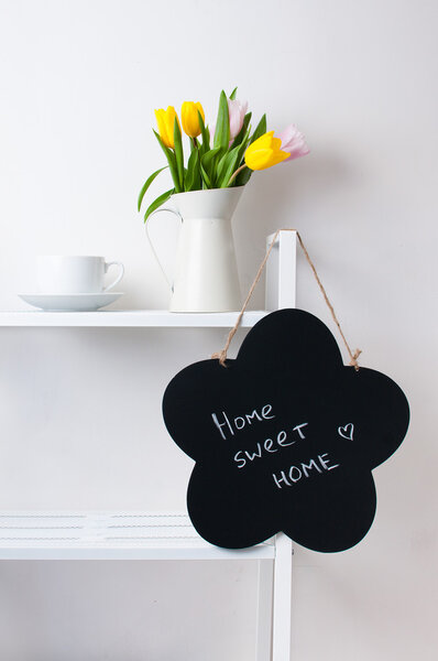 home interior decoration: a bouquet of tulips, a cup and a chal