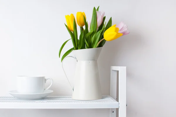 Boeket van tulpen en een kopje — Stockfoto