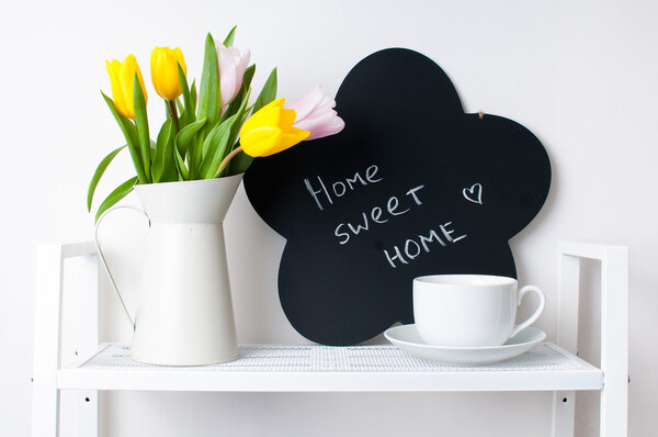 home interior decoration: a bouquet of tulips, a cup and a chal