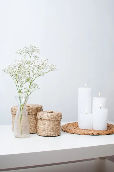 çiçek, beyaz mumlar ve iki kapalı sepet