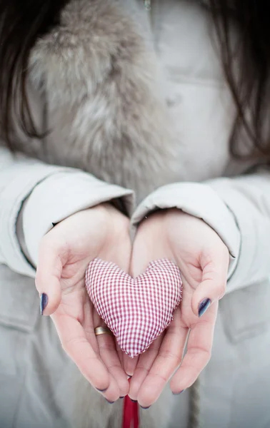 Corazón hecho de tela en las manos — Foto de Stock