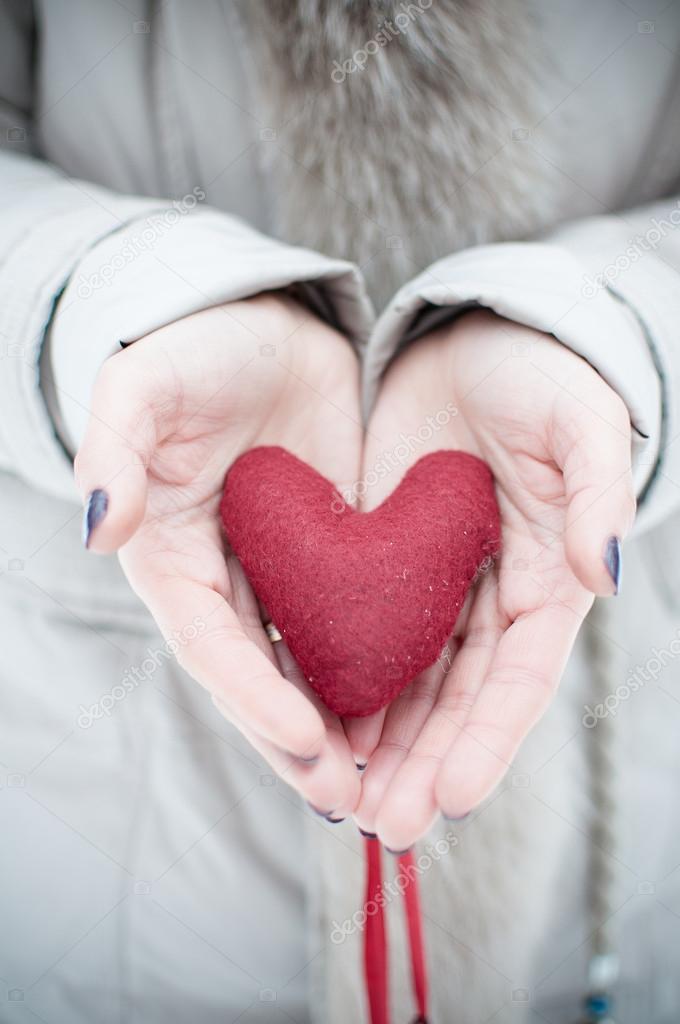 Red heart in woman's hands