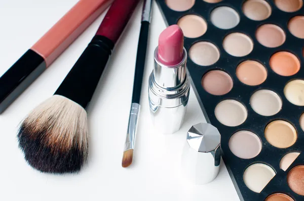 Kleurrijke eyeshadows, lippenstift en make-up borstels — Stockfoto