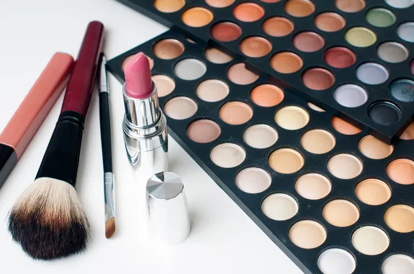 Colorful eyeshadows, lipstick and makeup brushes — Stock Photo, Image