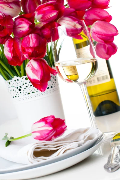 Glass of white wine and a bottle on festive table setting — Stock Photo, Image