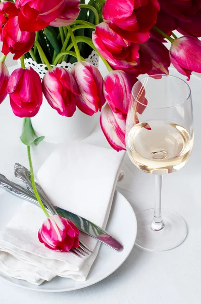 Glass of white wine and a festive table setting — Stock Photo, Image