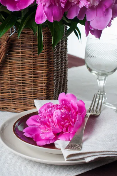 Tavola apparecchiata con peonie rosa, posate vintage e tavola marrone — Foto Stock