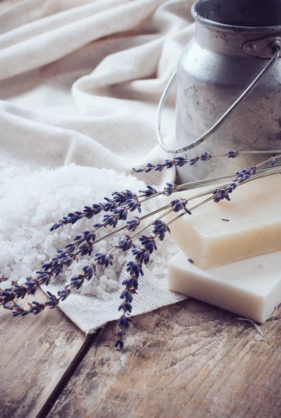 Soap, lavender, salt and old can on wooden board — Stock Photo, Image