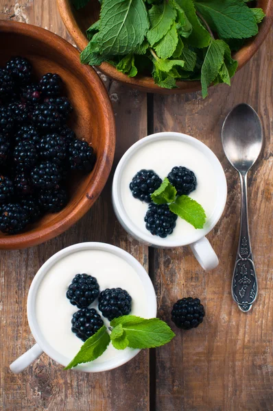 Two cups of creamy yogurt with blackberries — Stock Photo, Image