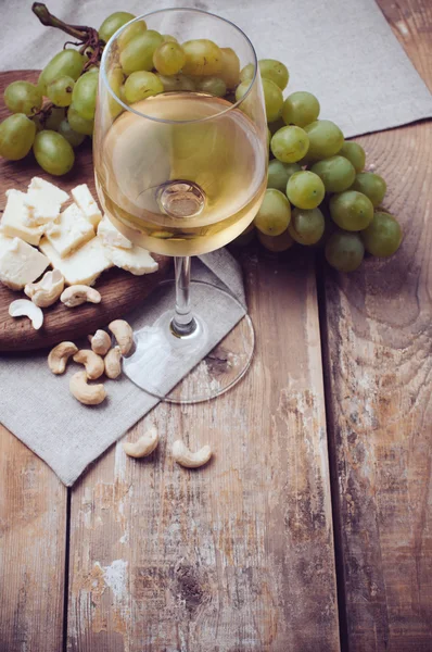 Glas vitt vin, druvor, cashewnötter och mjuk ost — Stockfoto