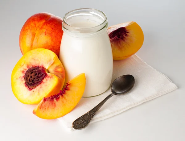 Jar of yogurt and sliced nectarines — Stock Photo, Image