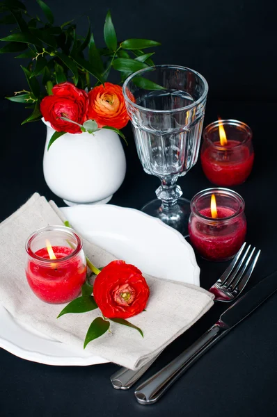 Ajuste de mesa con buñuelos rojos sobre fondo negro —  Fotos de Stock