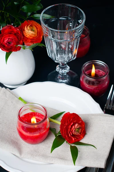 Apparecchiatura della tavola con ranuncoli rossi su sfondo nero — Foto Stock