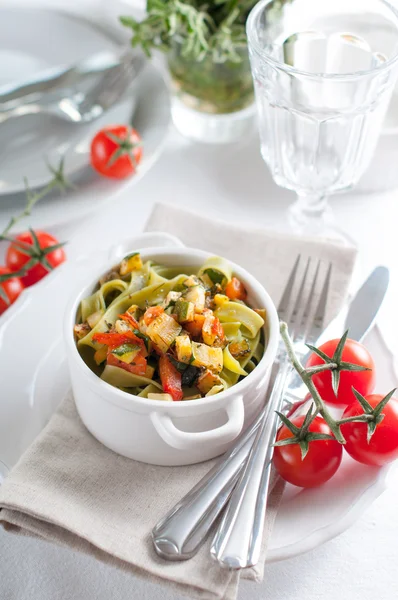 Kosten pasta med spenat, zucchini och körsbärstomater — Stockfoto