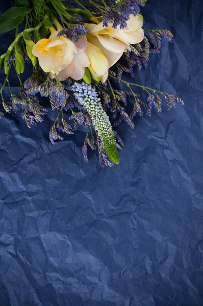 Цветы и голубая оберточная бумага — стоковое фото