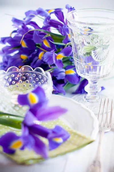De instelling van de tabel met paarse iris bloemen — Stockfoto