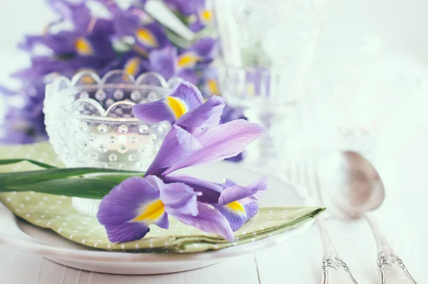 De instelling van de tabel met paarse iris bloemen — Stockfoto