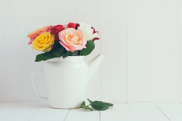 Bunte Rosen in weißer Emaille Kaffeekanne — Stockfoto