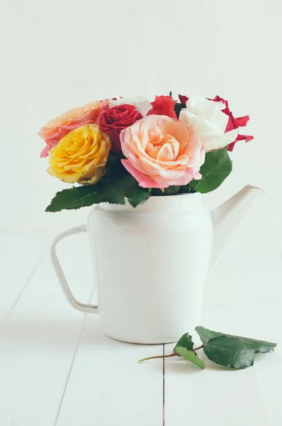 Bunte Rosen in weißer Emaille Kaffeekanne — Stockfoto