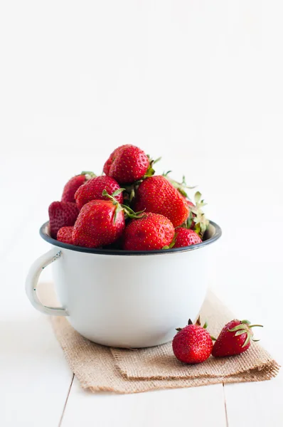 Aardbeien in wit geëmailleerd mok — Stockfoto